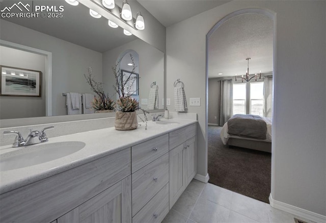 bathroom featuring tile patterned flooring, vanity, and a notable chandelier