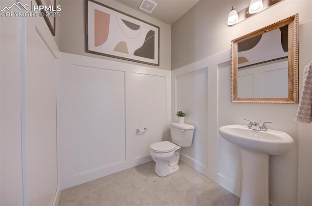 bathroom with tile patterned flooring, toilet, and sink