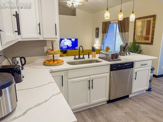 kitchen featuring stainless steel dishwasher, decorative light fixtures, white cabinetry, and sink