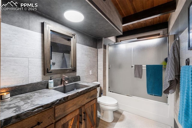 full bathroom featuring enclosed tub / shower combo, tile walls, beam ceiling, vanity, and toilet