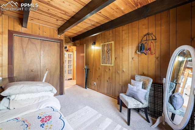 bedroom with light carpet, wooden walls, wooden ceiling, and beamed ceiling