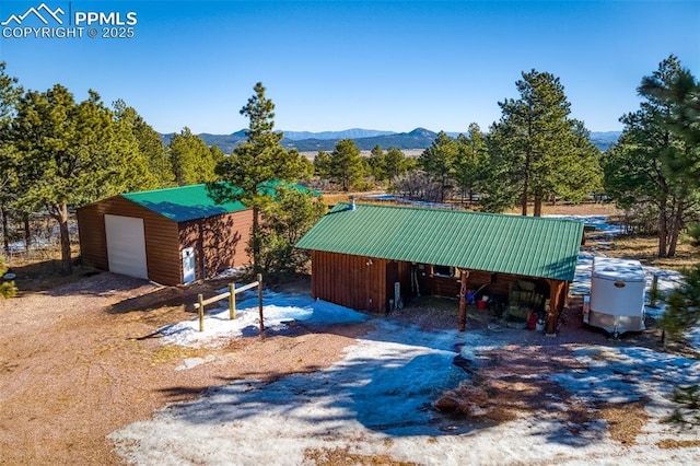 exterior space with a garage, an outdoor structure, and a mountain view