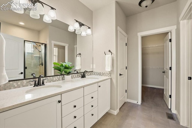 bathroom featuring vanity, tasteful backsplash, tile patterned floors, and an enclosed shower