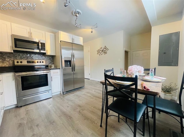 kitchen with white cabinets, backsplash, stainless steel appliances, and electric panel