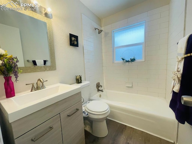 full bathroom featuring wood-type flooring, vanity, toilet, and tiled shower / bath combo