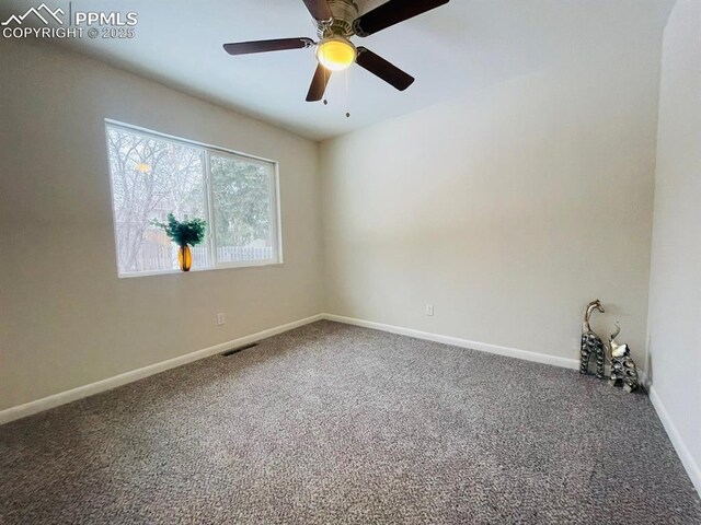 carpeted spare room with ceiling fan