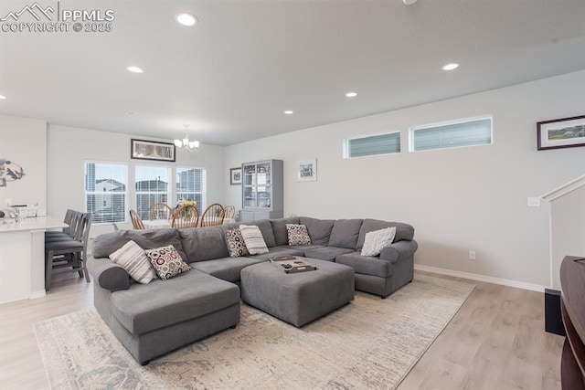 living room with a chandelier and light hardwood / wood-style flooring