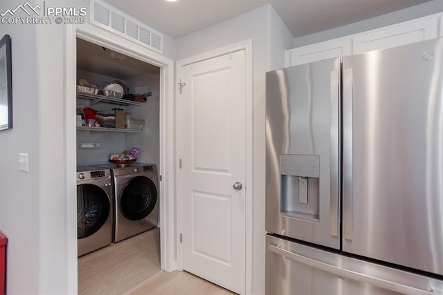 laundry area featuring light wood-type flooring and independent washer and dryer