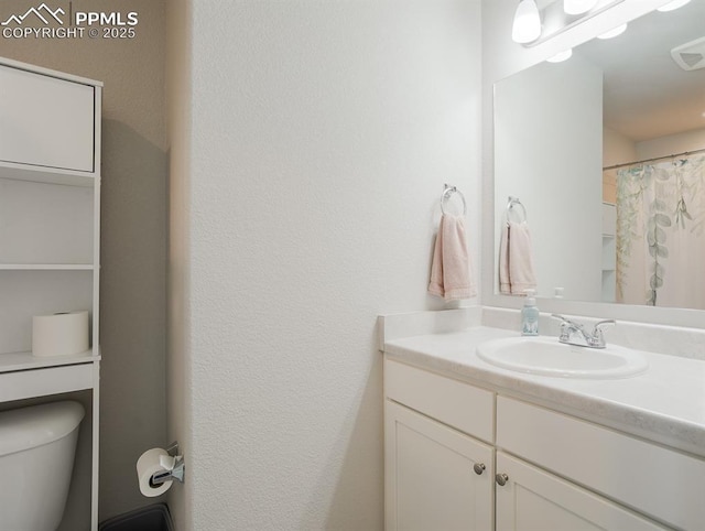 bathroom with a shower with shower curtain, vanity, and toilet