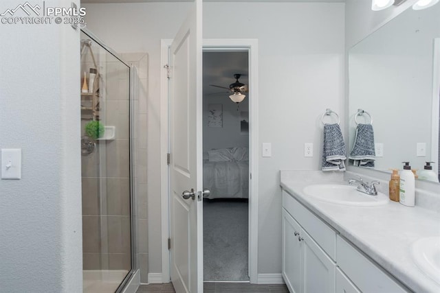 bathroom with ceiling fan, a shower with shower door, and vanity