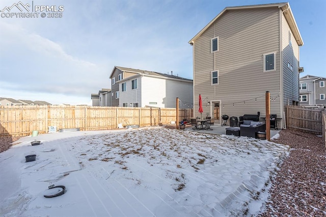 snow covered back of property with an outdoor hangout area