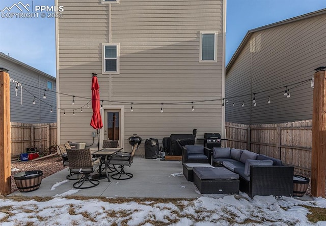 snow covered rear of property with an outdoor living space and a patio area