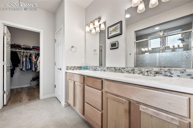 bathroom featuring tasteful backsplash, tile patterned flooring, an enclosed shower, and vanity