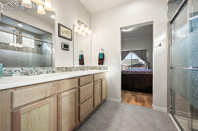 bathroom with a wealth of natural light, tile patterned flooring, backsplash, and vanity