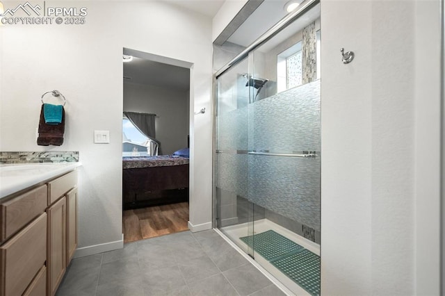 bathroom featuring tile patterned flooring, walk in shower, and vanity