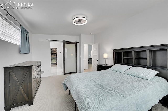 bedroom featuring light carpet and a barn door