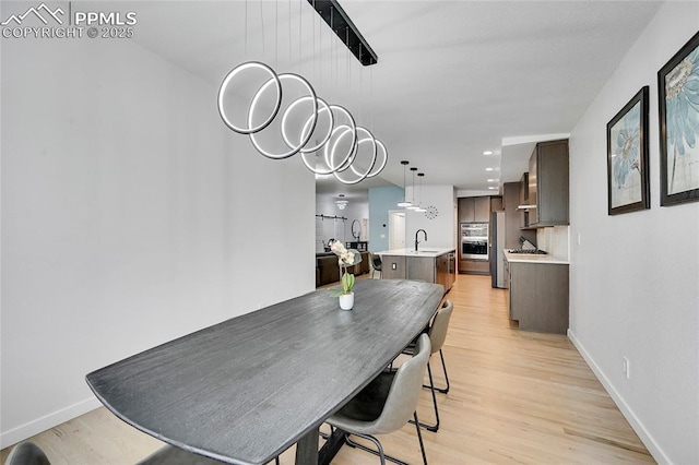 dining room with light hardwood / wood-style flooring and sink