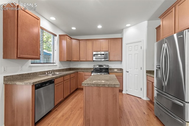 kitchen featuring light hardwood / wood-style floors, sink, stainless steel appliances, and a center island