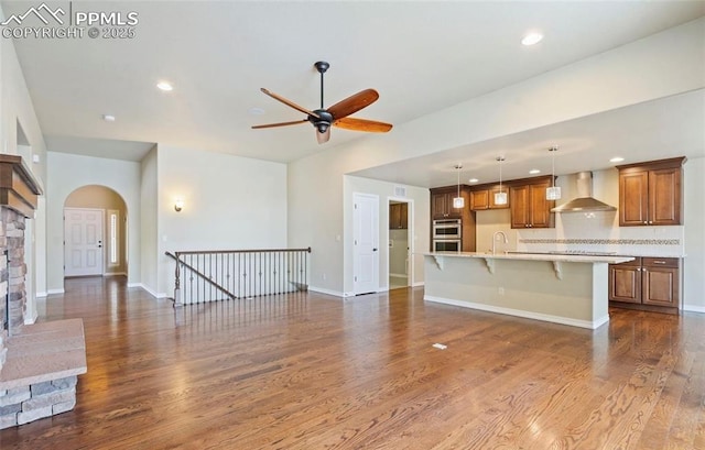 unfurnished living room featuring dark hardwood / wood-style flooring, ceiling fan, and sink