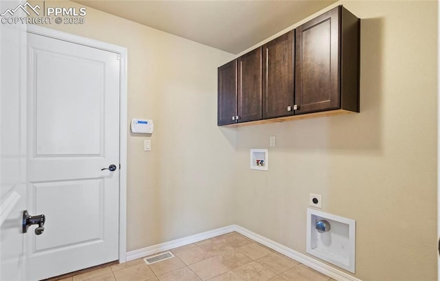 clothes washing area with washer hookup, electric dryer hookup, cabinets, and light tile patterned floors