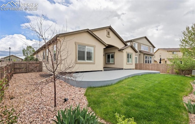 back of house featuring a patio area and a yard