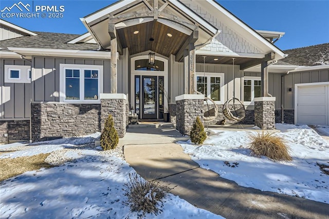 snow covered property entrance featuring a garage