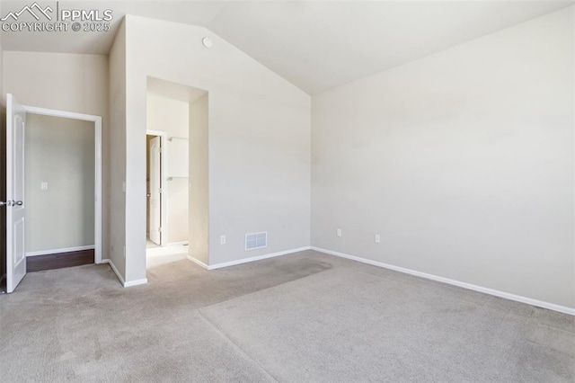 unfurnished bedroom featuring vaulted ceiling and light carpet