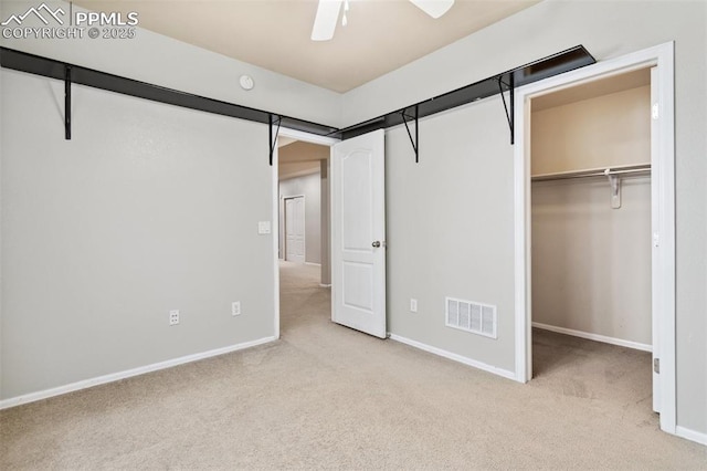 unfurnished bedroom featuring ceiling fan, light colored carpet, and a closet