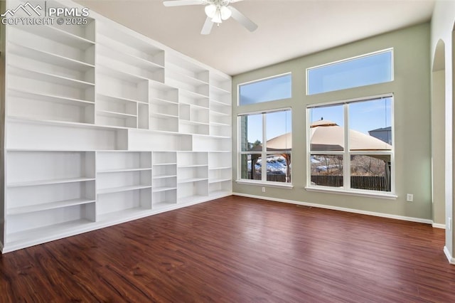 unfurnished living room with ceiling fan, dark hardwood / wood-style flooring, and built in features