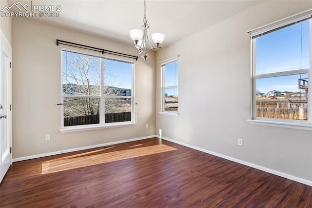 unfurnished room with wood-type flooring and a notable chandelier