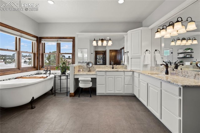 bathroom with a washtub, vanity, and tile patterned floors