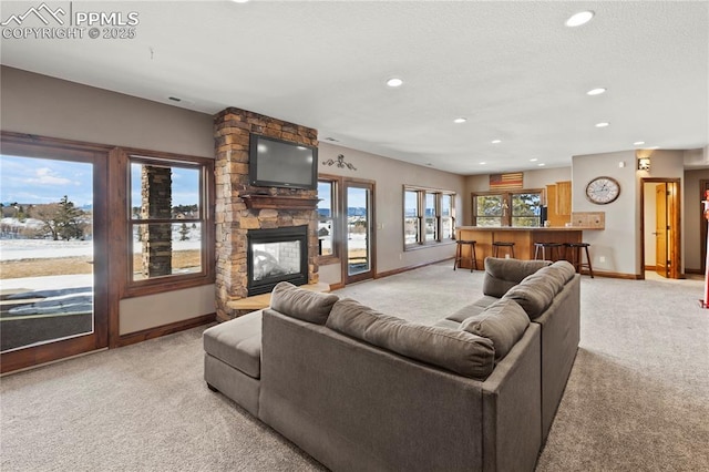 carpeted living room featuring a stone fireplace