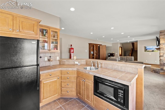 kitchen with black appliances, sink, tasteful backsplash, tile counters, and kitchen peninsula