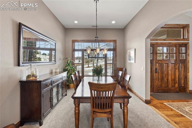 dining room featuring light carpet and a chandelier