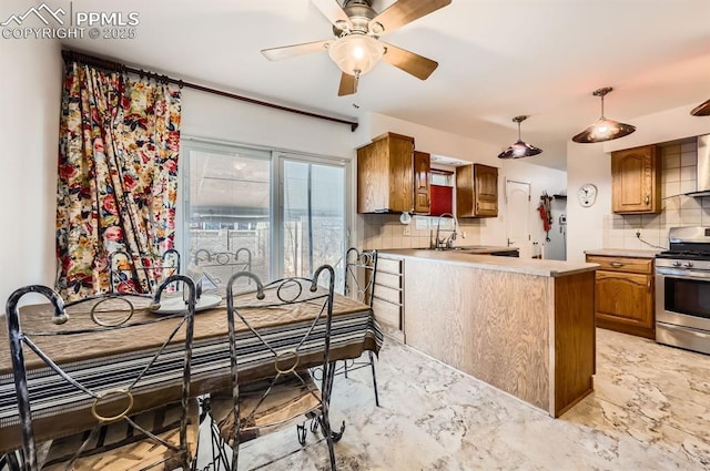 kitchen with sink, backsplash, ceiling fan, kitchen peninsula, and gas range