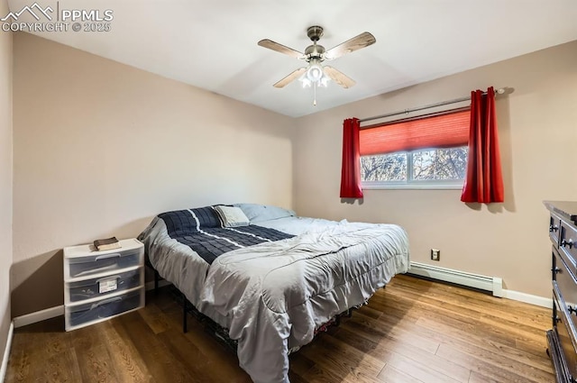 bedroom with hardwood / wood-style flooring, a baseboard heating unit, and ceiling fan