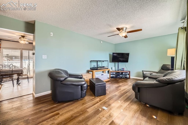 living room with hardwood / wood-style floors, a textured ceiling, and ceiling fan