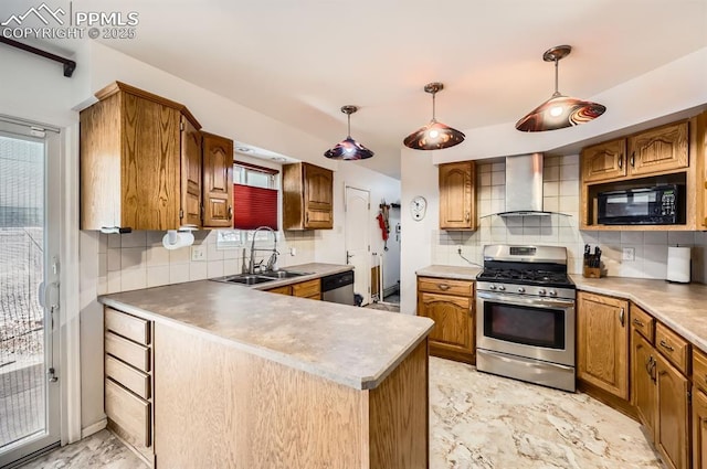 kitchen with sink, decorative light fixtures, stainless steel appliances, and wall chimney exhaust hood