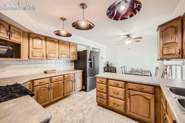 kitchen featuring stainless steel refrigerator with ice dispenser, range, pendant lighting, ceiling fan, and decorative backsplash