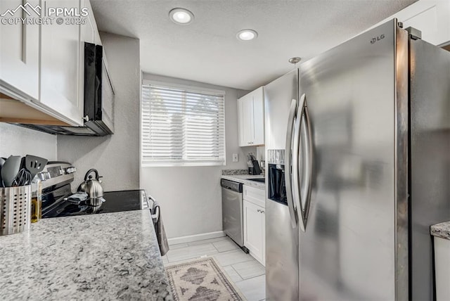 kitchen with white cabinetry, light stone counters, and appliances with stainless steel finishes