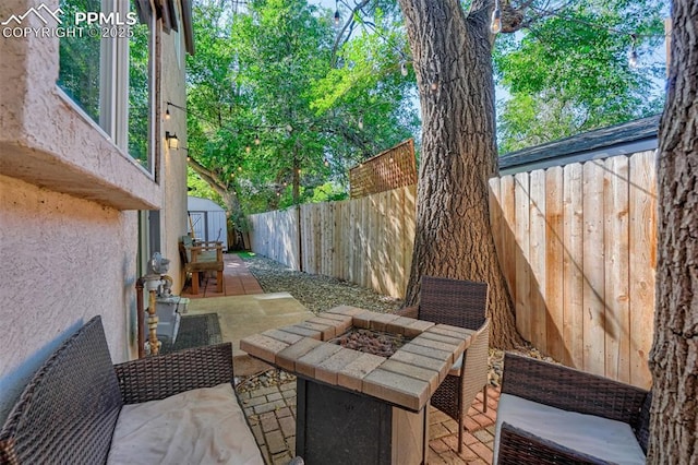 view of patio / terrace featuring a storage shed and an outdoor fire pit