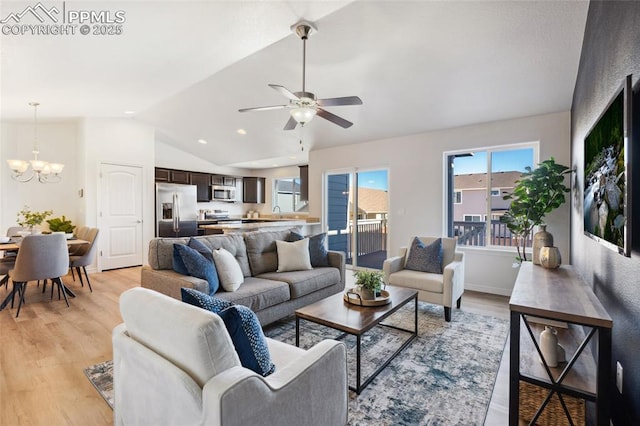 living room with ceiling fan with notable chandelier, vaulted ceiling, and light wood-type flooring