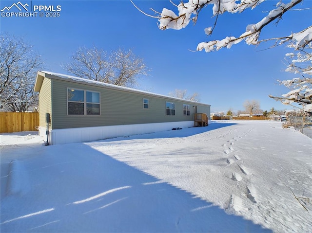 view of snow covered back of property