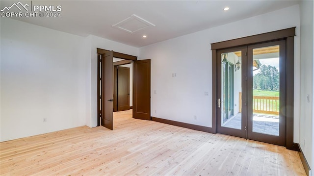 spare room with french doors and light wood-type flooring