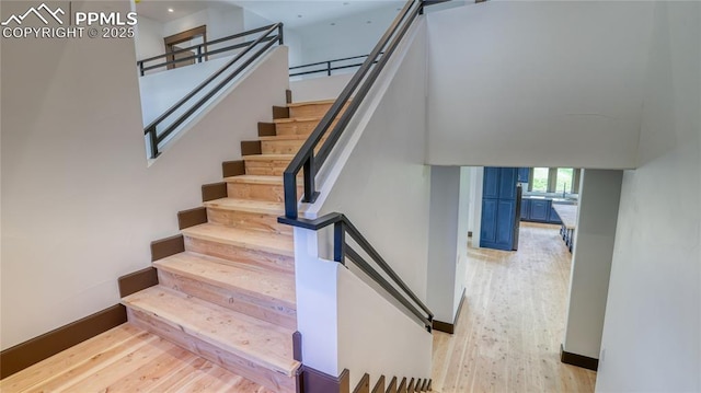 staircase with hardwood / wood-style floors