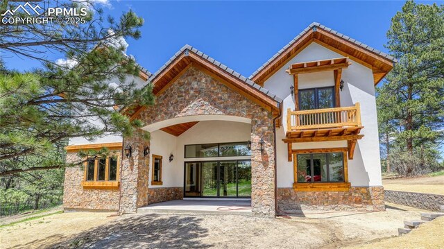 rear view of house with a balcony and a patio area