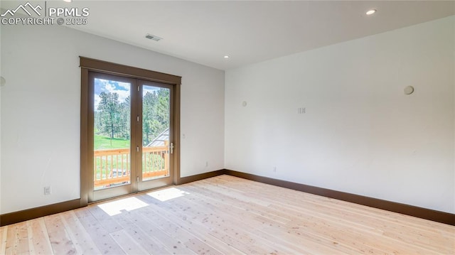 empty room with french doors and light hardwood / wood-style floors