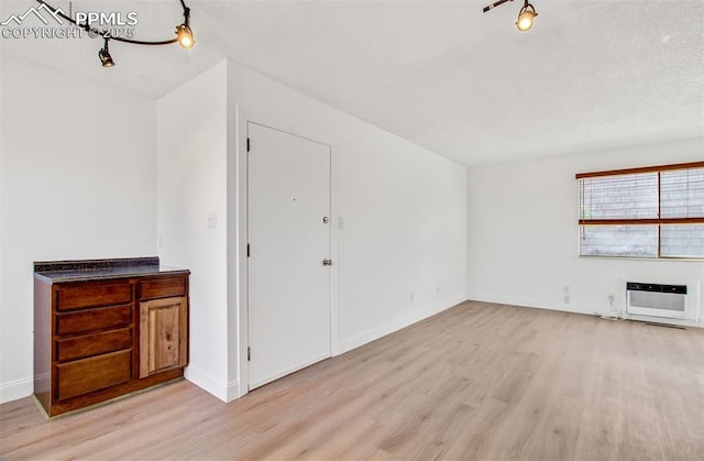 unfurnished living room with light hardwood / wood-style flooring and heating unit