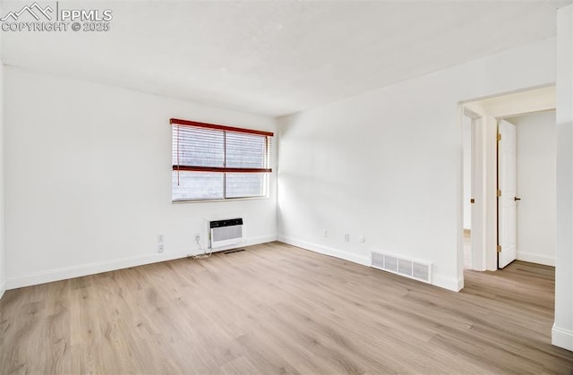 spare room with light hardwood / wood-style floors and heating unit