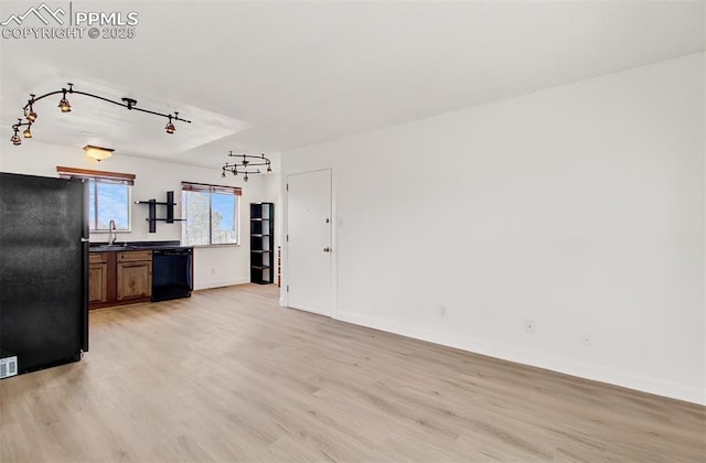 kitchen with light hardwood / wood-style floors, black appliances, and sink